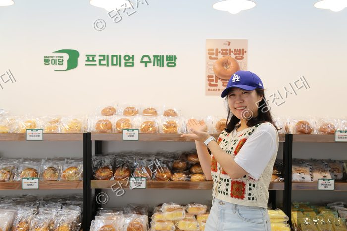 당진의 한 빵집에서 점장이 빵 진열대 앞에서 포즈를 취하고 있다.