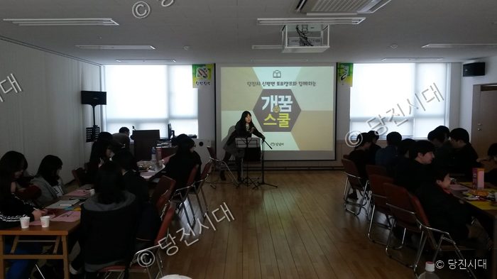 강당에서 학생들이 강사의 설명을 들으며 교육을 받고 있다.
