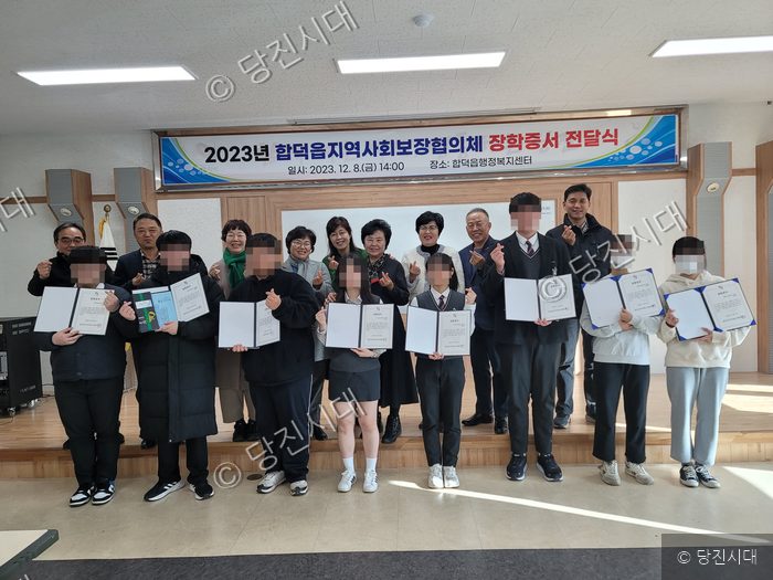 합덕읍지역사회보장협의체가 학생들이 모여 장학증서 전달식을 하고 있다.
