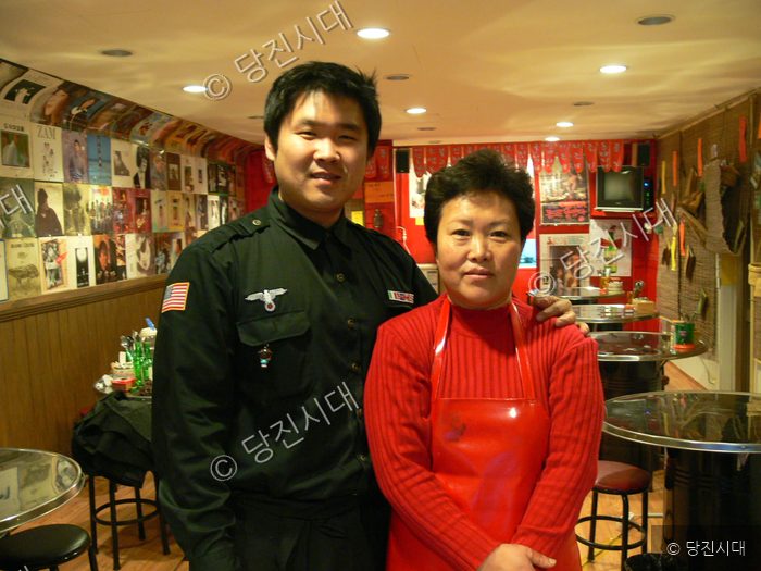식당 안에서 남녀가 포즈를 취하고 있다.