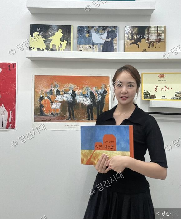 한 여성이 당진수청점 파리아트마인에서 책을 들고 포즈를 취하고 있다.