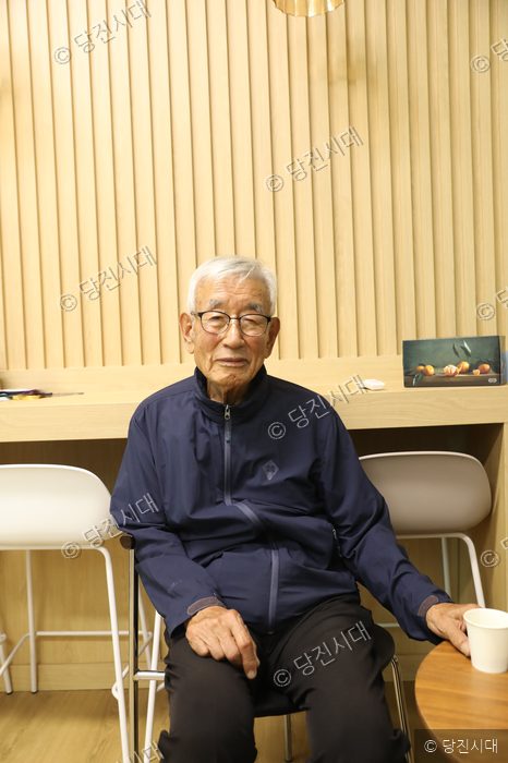 신양웅 전 석문중학교 교장이 실내에 앉아 있다.
