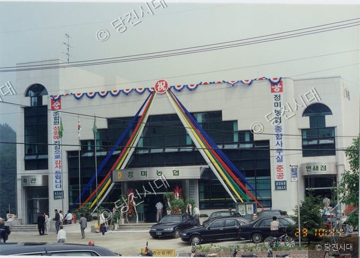 정미농협 종합사무실 준공식 행사장에서 사람들이 기념촬영을 하고 있다.