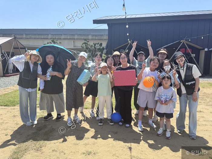당진시가족센터 돌봄품앗이 프로그램에 참여한 김민정 센터장 가족이 야외에서 기념촬영을 하고 있다.