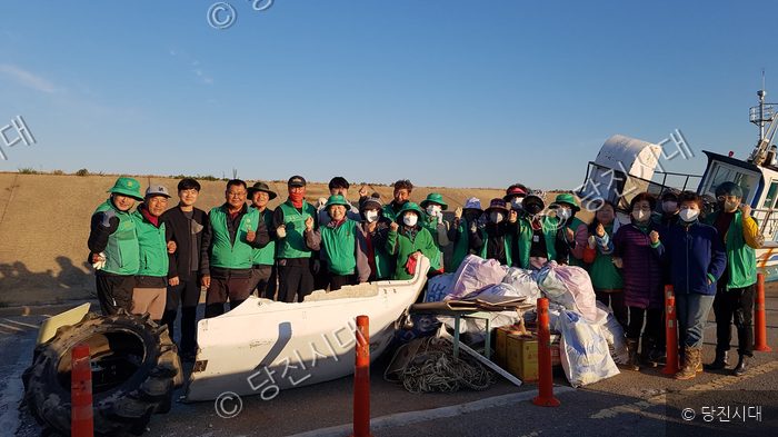 석문면 주민들이 바닷가에서 쓰레기 수거 봉사활동을 하고 있다.