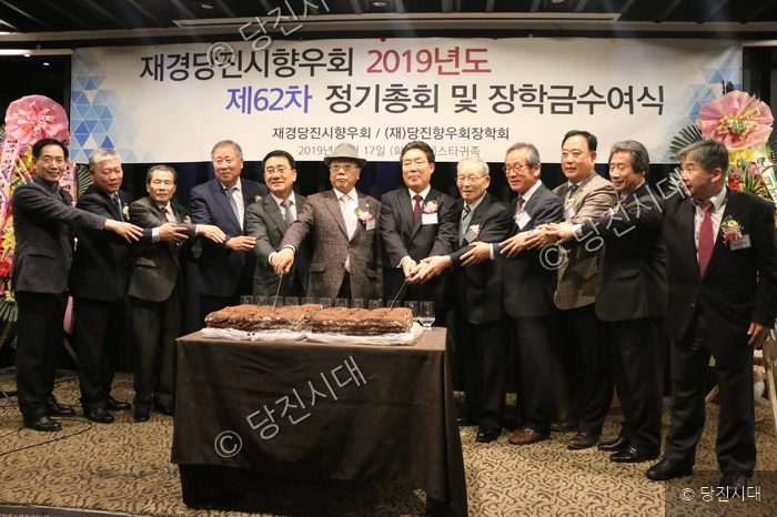 참석자들이 장학금 수여식 기념 케이크를 자르고 있다.