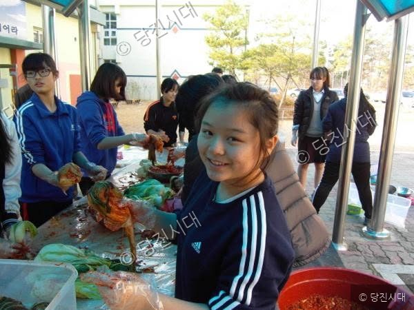 순성중학교 학생들이 김장을 담그며 미소를 짓고 있다.