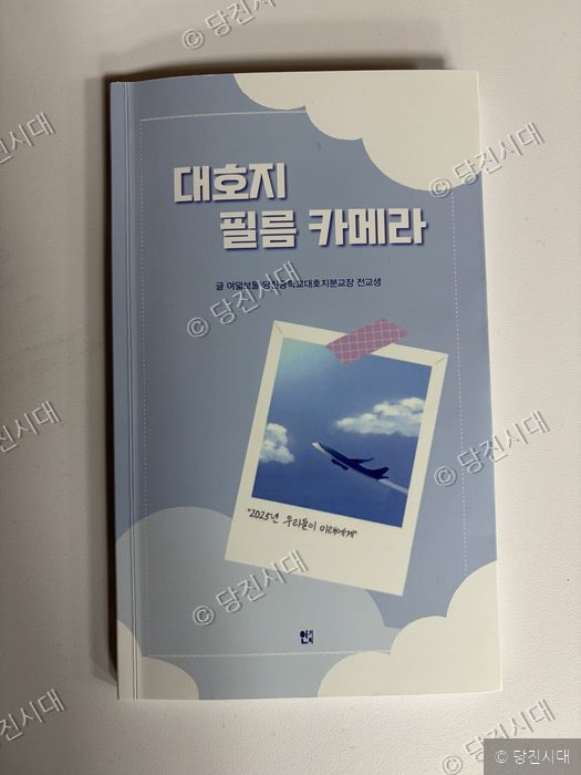 하늘과 비행기가 담긴 폴라로이드 사진이 있는 책 표지다.