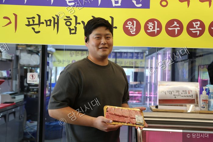 한돈농원 당진점 구준모 대표가 판매용 고기 팩을 들고 미소 짓고 있다.