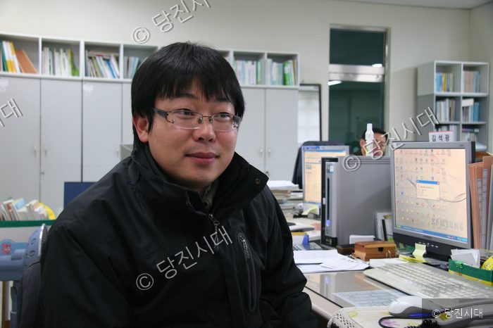 사무실 책상에 앉은 남성이 인터뷰에 응하고 있다.
