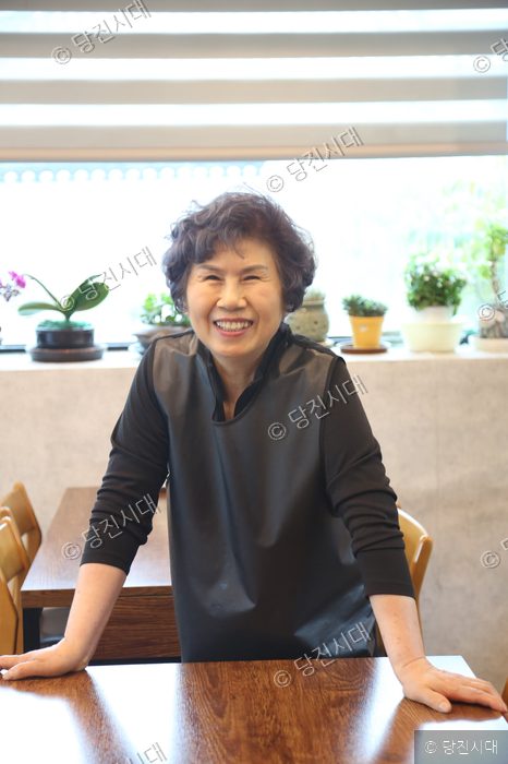 수청회관의 대표가 밝은 미소로 카메라를 향해 포즈를 취하고 있다.