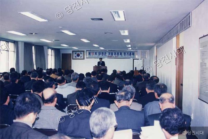실내 강당에서 많은 사람들이 참석한 가운데 행사가 진행되고 있다.
