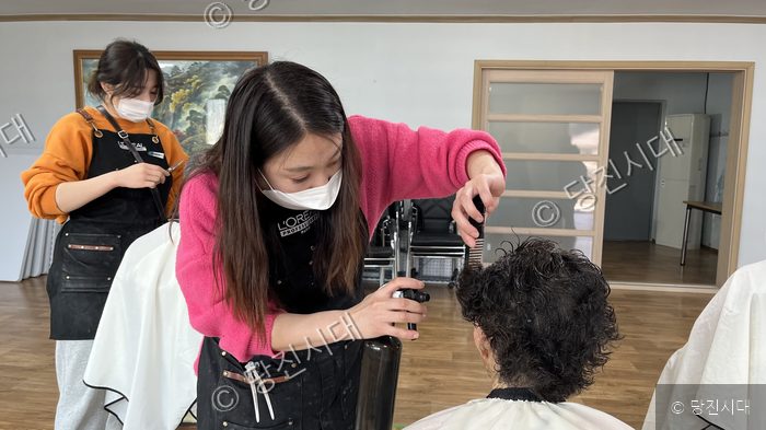 자원봉사자가 어르신을 대상으로 미용 봉사를 하고 있다.