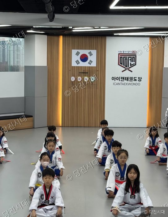 아이캔태권도장에서 원생들이 도복을 입고 앉아 있다.