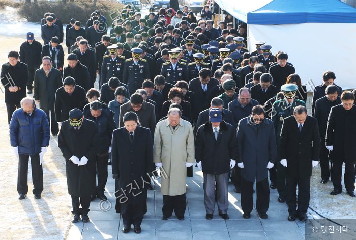 많은 사람들이 송악 나라사랑공원에서 고개를 숙여 묵념하고 있다.