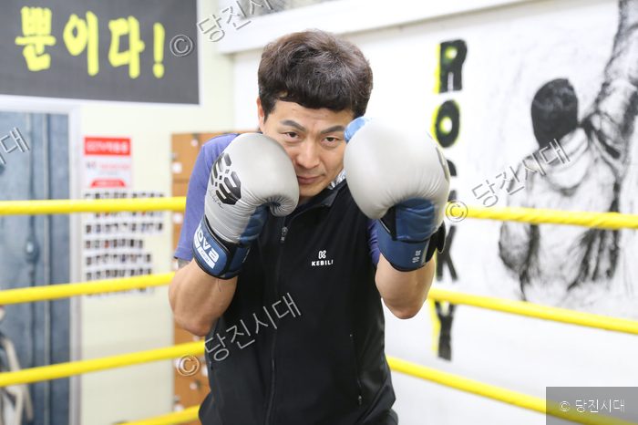 박성일 씨가 복싱 체육관에서 글러브를 끼고 포즈를 취하고 있다.