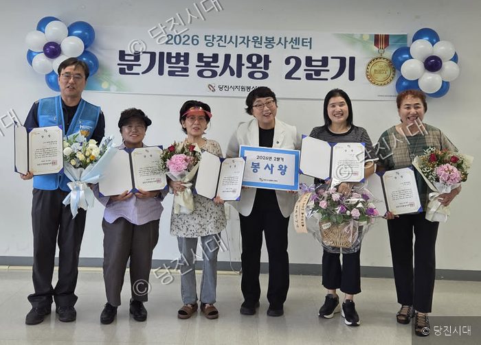 당진시자원봉사센터 관계자들과 수상자들이 2분기 봉사왕 시상식에서 상장과 꽃다발을 들고 기념 촬영을 하고 있다.