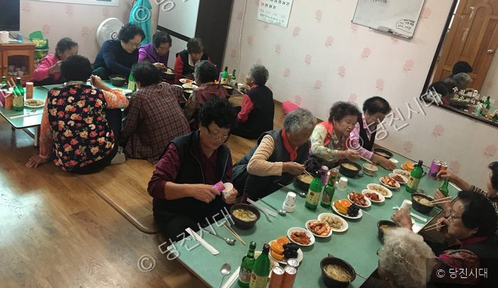 어르신들이 모여 앉아 식사를 하며 정을 나누고 있다.