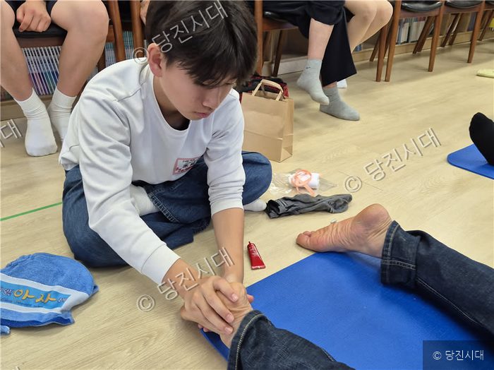 이건일 관장이 어버이날 행사의 일환으로 어르신의 발을 마사지하고 있다