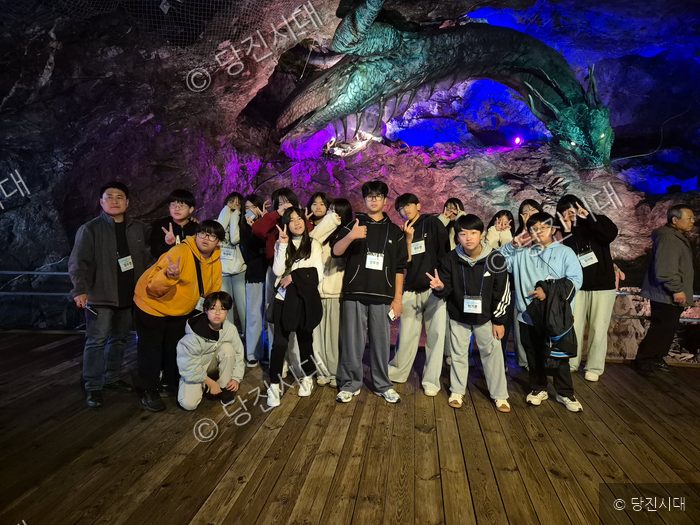 송악중학교 학생들이 동굴 견학지에서 기념촬영을 하고 있다.