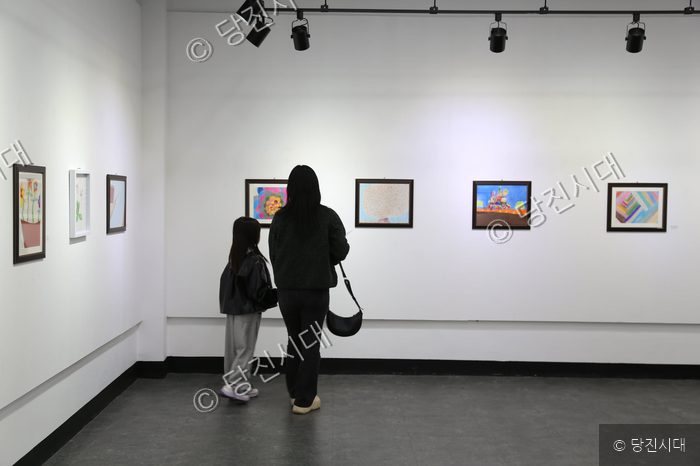 관람객들이 미술관에서 전시된 작품들을 감상하고 있다.