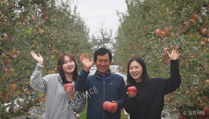 사과 농장에서 성은영 대표 등이 사과를 들고 미소 짓고 있다.