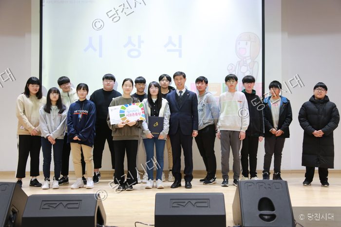 청소년들이 시상식에서 상장을 들고 포즈를 취하고 있다.