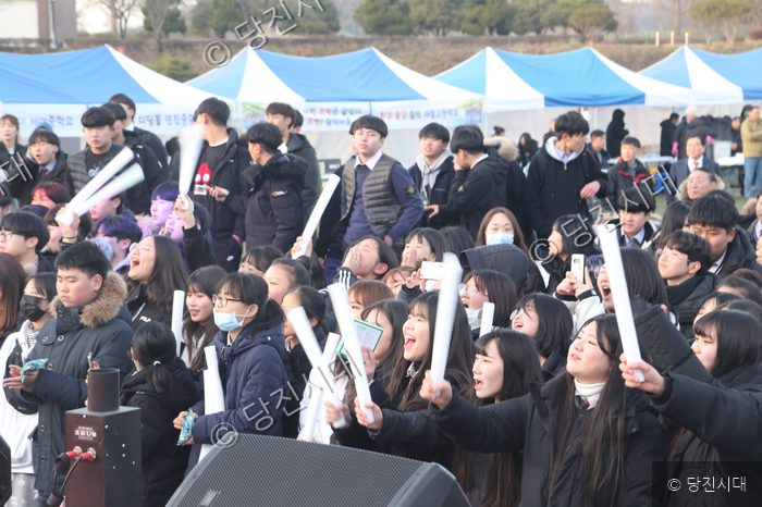 학생들이 축제에서 응원 도구를 흔들며 즐거워하고 있다.