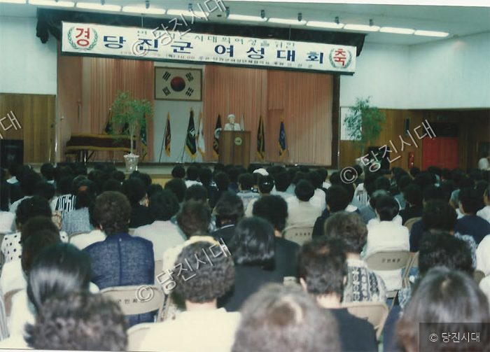 많은 사람들이 모여 실내에서 행사가 진행되고 있다.