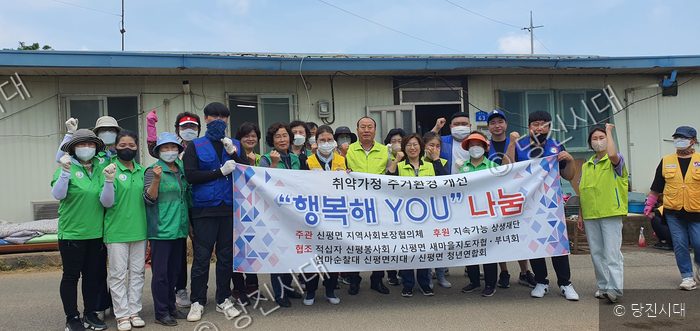 봉사자들이 주거환경 개선 사업 현장에서 기념촬영을 하고 있다.
