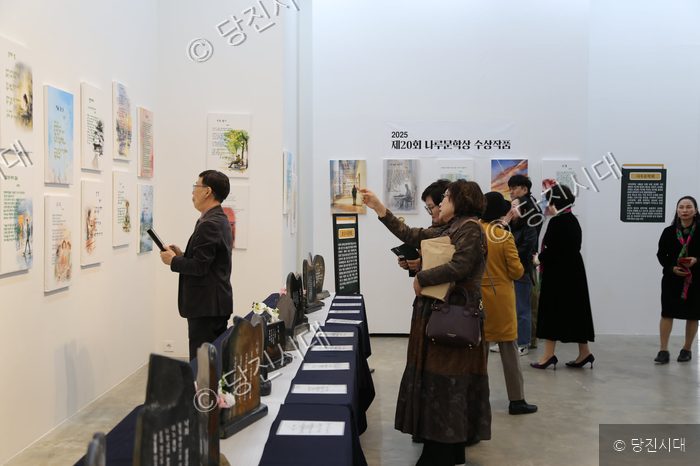 김명수 작가 등이 당진문학제 전시장을 찾아 수상 작품들을 관람하고 있다.
