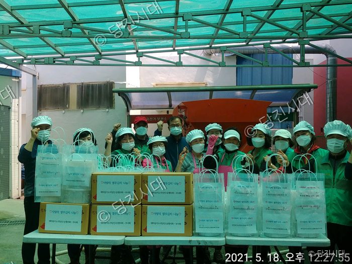 당진시 새마을지도자협의회와 부녀회원들이 열무김치 나눔 행사를 열고 기념 촬영을 하고 있다.