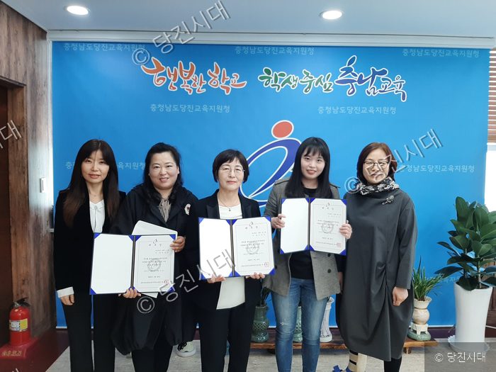 충청남도당진교육지원청에서 관계자들이 위촉장을 들고 기념 촬영을 하고 있다.