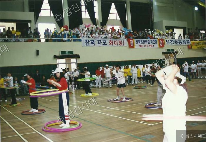 실내 체육관에서 참가자들이 훌라후프 대회를 하고 있다.