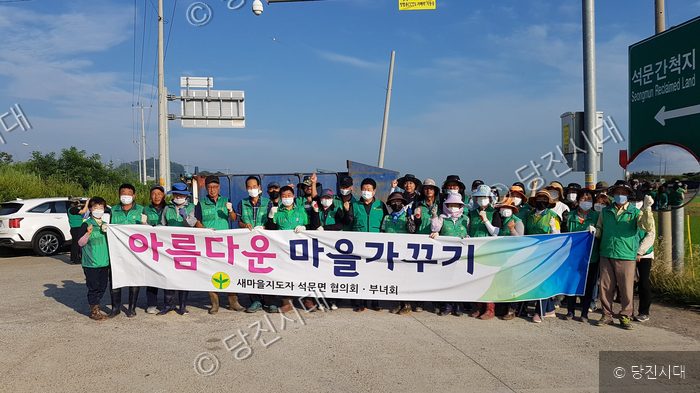 석문면 새마을지도자 협의회·부녀회원들이 마을가꾸기 행사를 기념하고 있다.