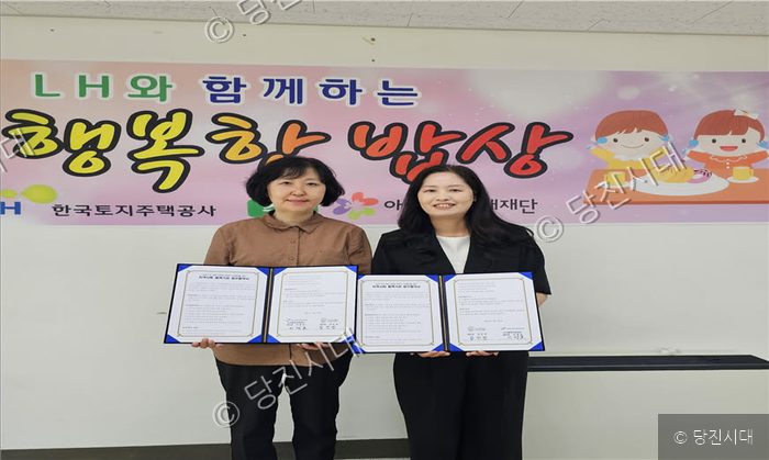 두 여성이 복지 협약을 체결한 뒤 기념 촬영을 하고 있다.