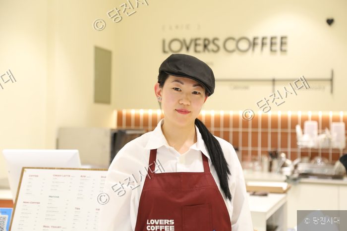 러버스커피 매장에서 점장이 포즈를 취하고 있다.