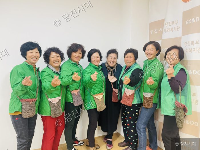 당진북부사회복지관에서 새마을운동 참여자들이 손가락 하트 포즈를 취하고 있다.