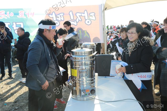 당진땅 수호 집회 현장에서 참가자들이 음료를 나누어 마시고 있다.