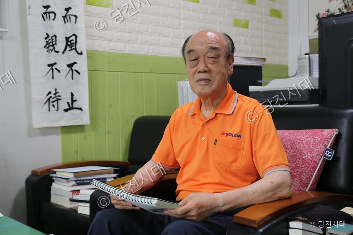 김익진 씨가 실내에서 책을 보며 앉아 있다.