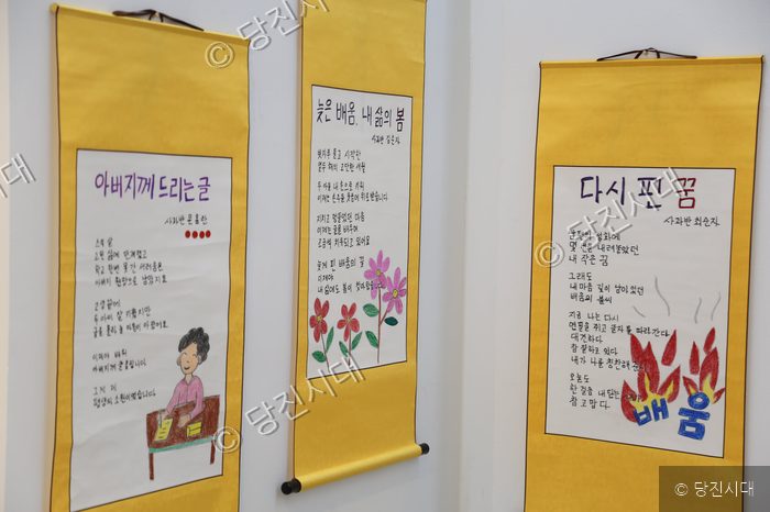전시된 어르신들의 문해교육 시화 작품들을 보여주고 있다.