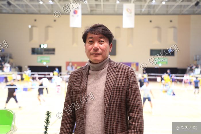 김용성 배드민턴 회장이 대회장에서 포즈를 취하고 있다.