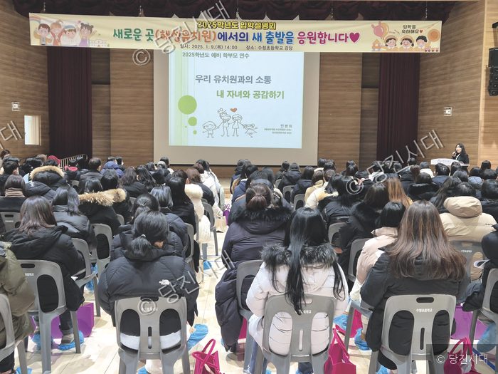 강당에서 학부모들이 유치원 입학 설명회를 듣고 있다.