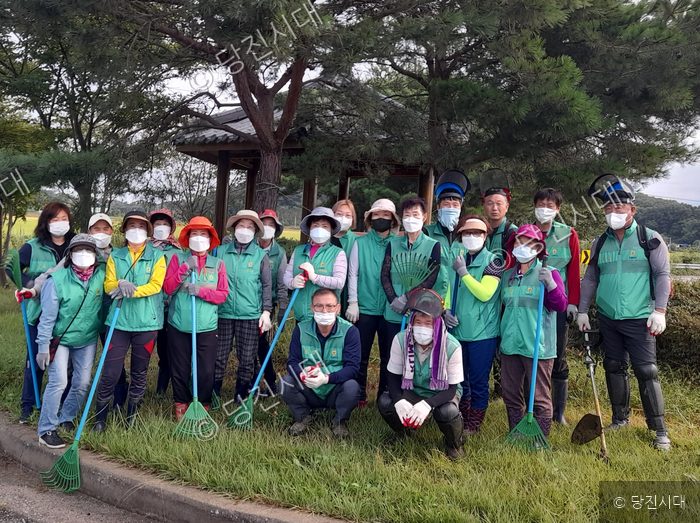 당진시 송산면 주민들이 지역 내 환경 정화 봉사활동을 마치고 기념 촬영을 하고 있다.