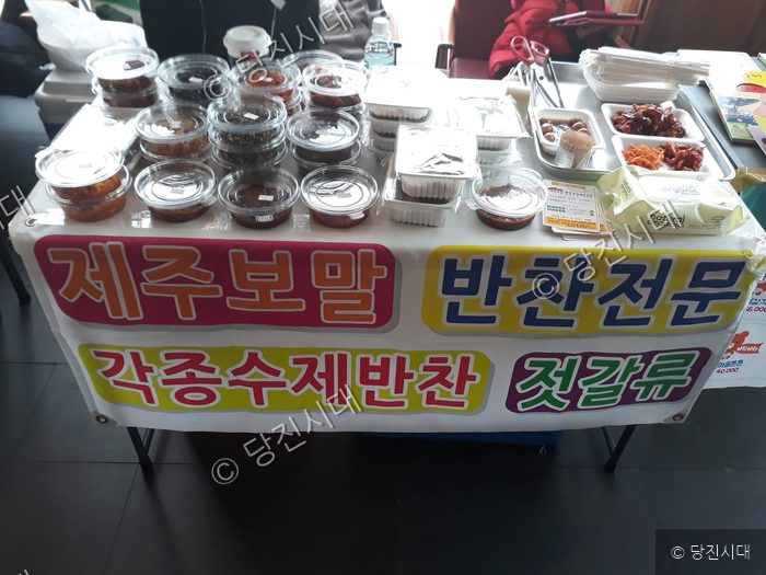 테이블 위에 다양한 반찬과 젓갈이 진열되어 있다.