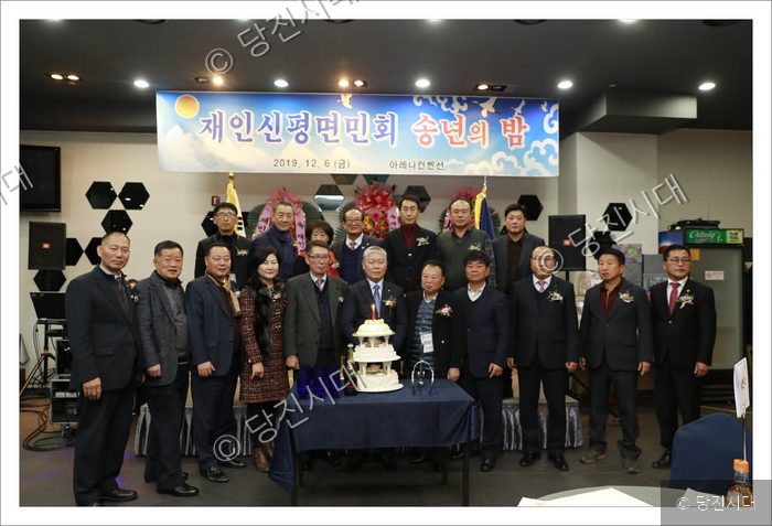 재인신평면민회 회원들이 송년의 밤 행사에서 기념 케이크를 자르고 있다.