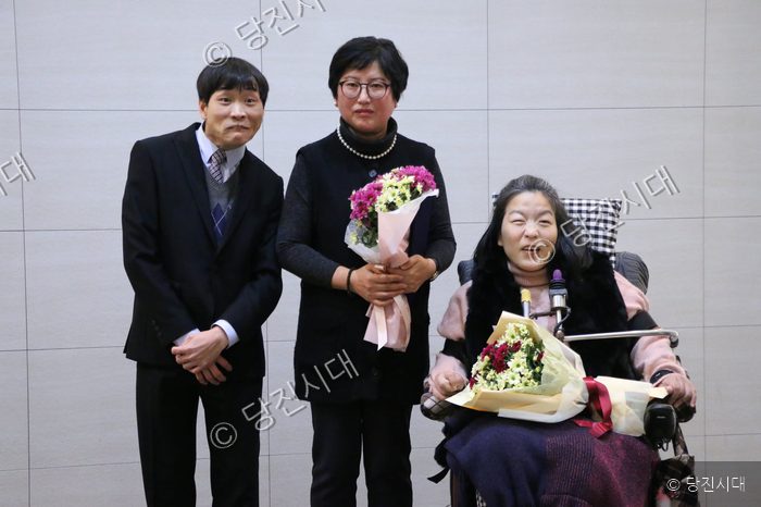 중증장애인자립생활지원센터 관계자들이 활동보고회에서 꽃다발을 들고 기념 촬영을 하고 있다.