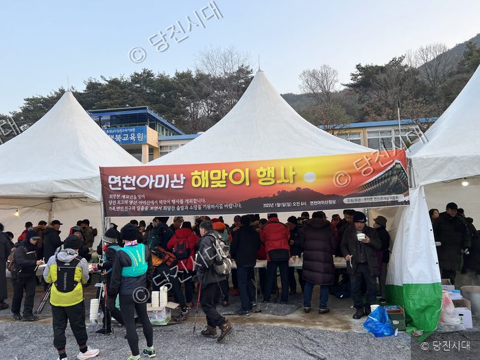 주민들이 면천 아미산 해맞이 행사에서 떡국 등을 나누어 먹고 있다.