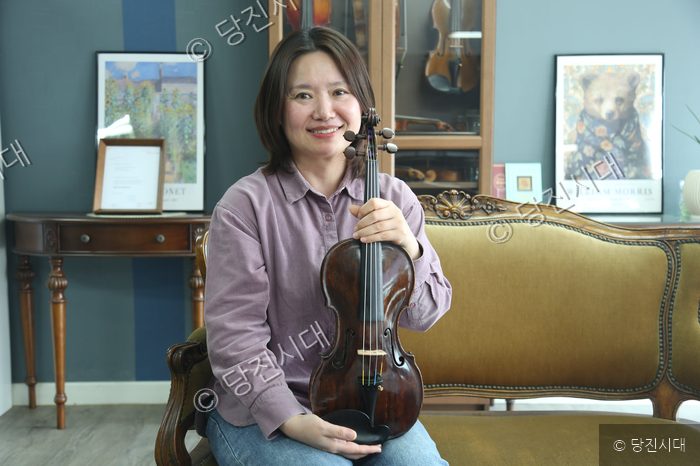 현정원 김해윤 대표가 바이올린을 들어 보이고 있다.