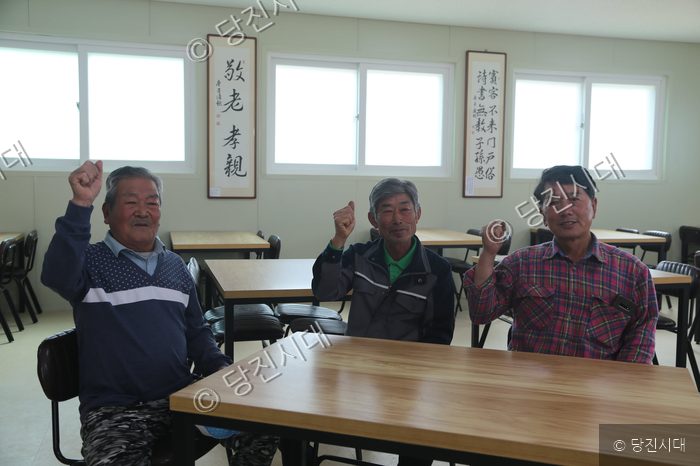 대호지면 적서리 마을에서 세 명의 주민이 주먹을 쥐고 포즈를 취하고 있다.